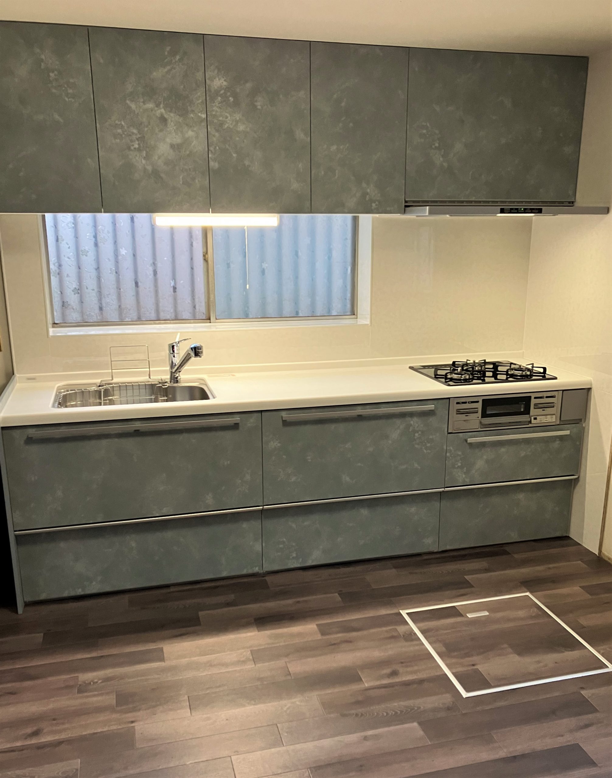 モノトーンのグレーキッチン×落ち着いた色味のフローリングで 洗練された雰囲気を演出する空間に